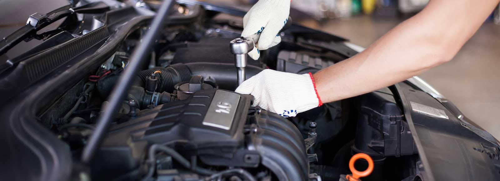 Mechanic servicing an engine with a ratchet at Quality Truck And Bus Repair